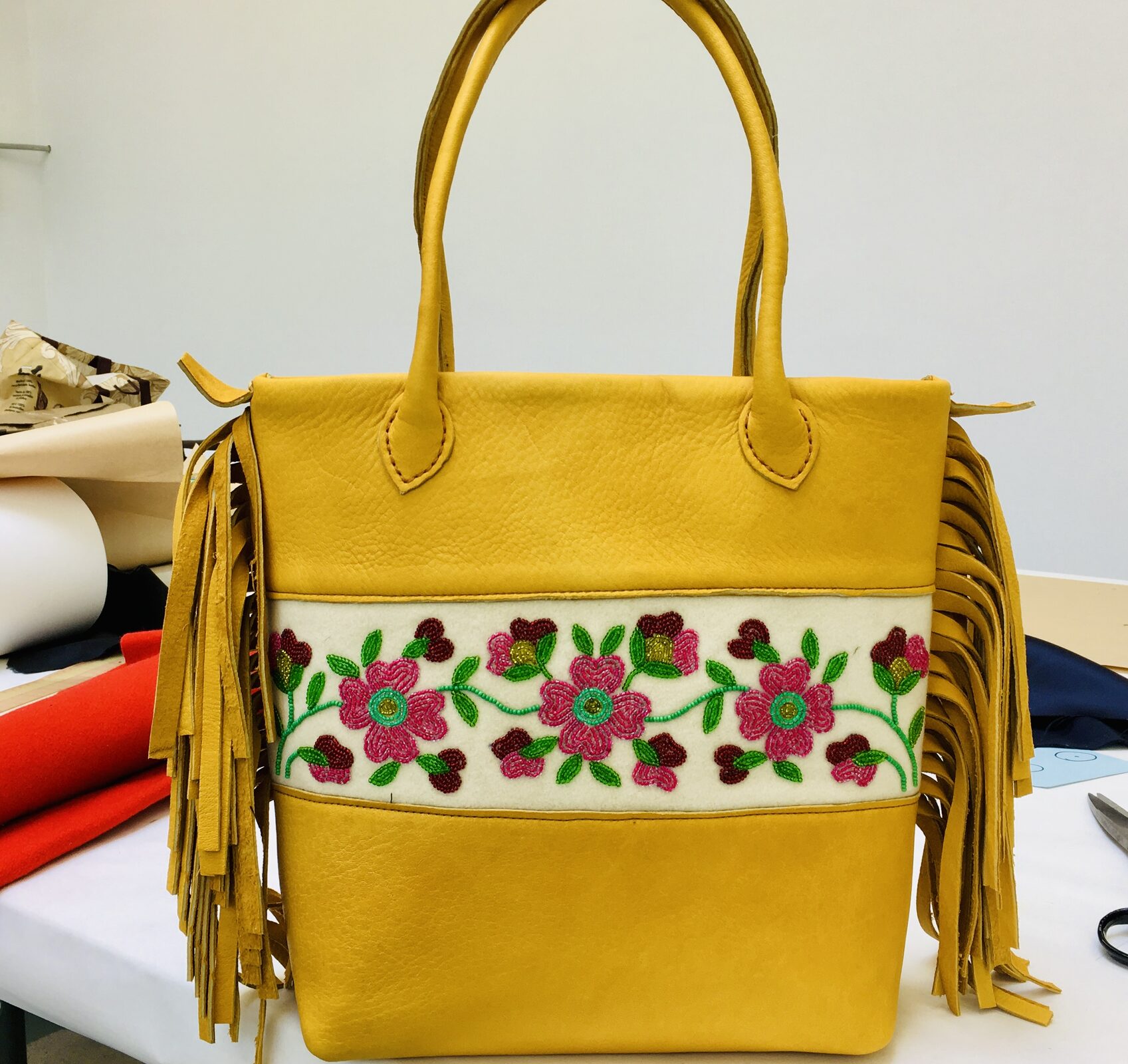 Mustard leather tote with a beaded rose vine and hide fringe.