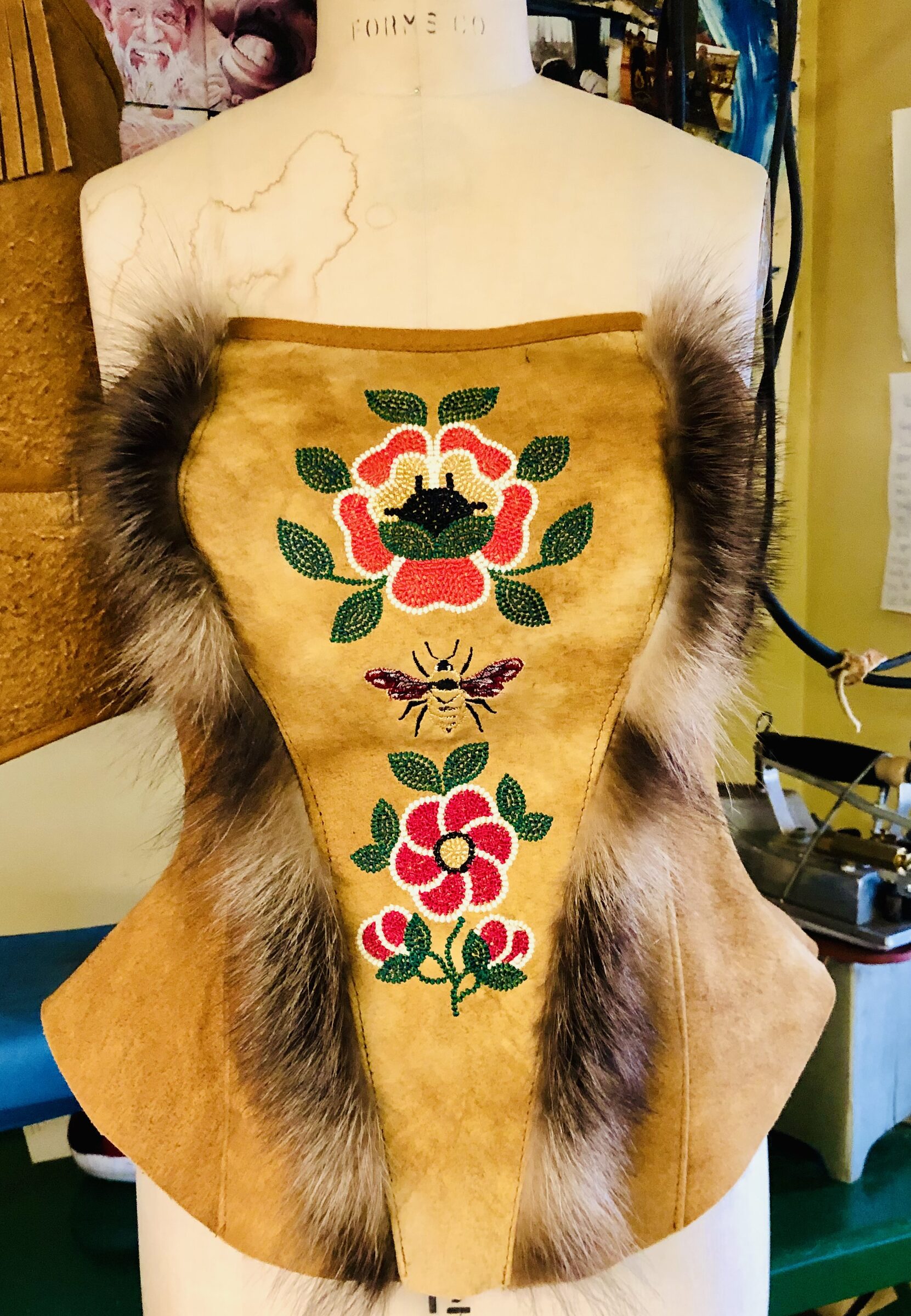 Beaded hide bustier with fox and floral beadwork, including a beaded bee, on a dress form.