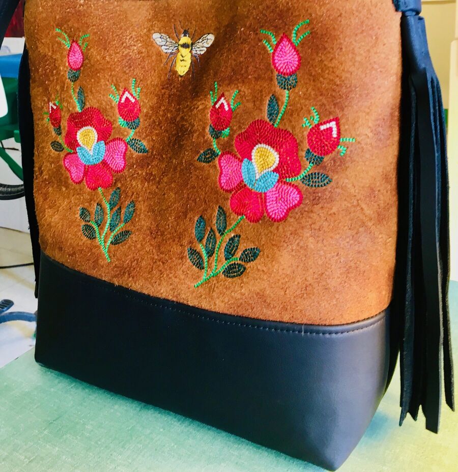 Tan hide tote with two beaded roses and a bee