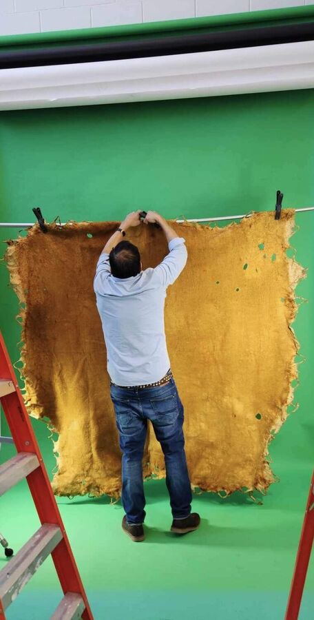 A large moose hide hung on a line in the studio