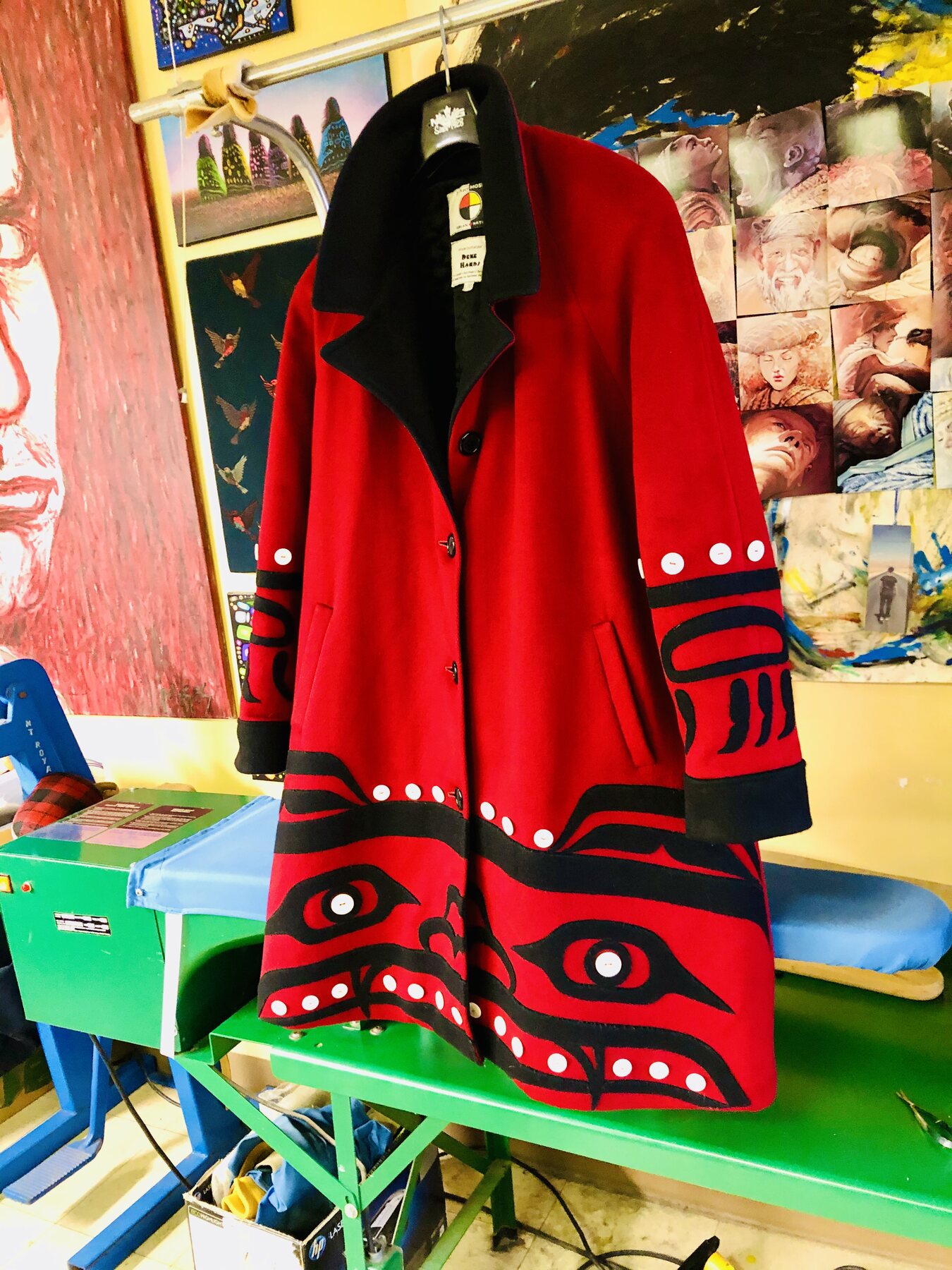 Red and black formline coat on a studio table